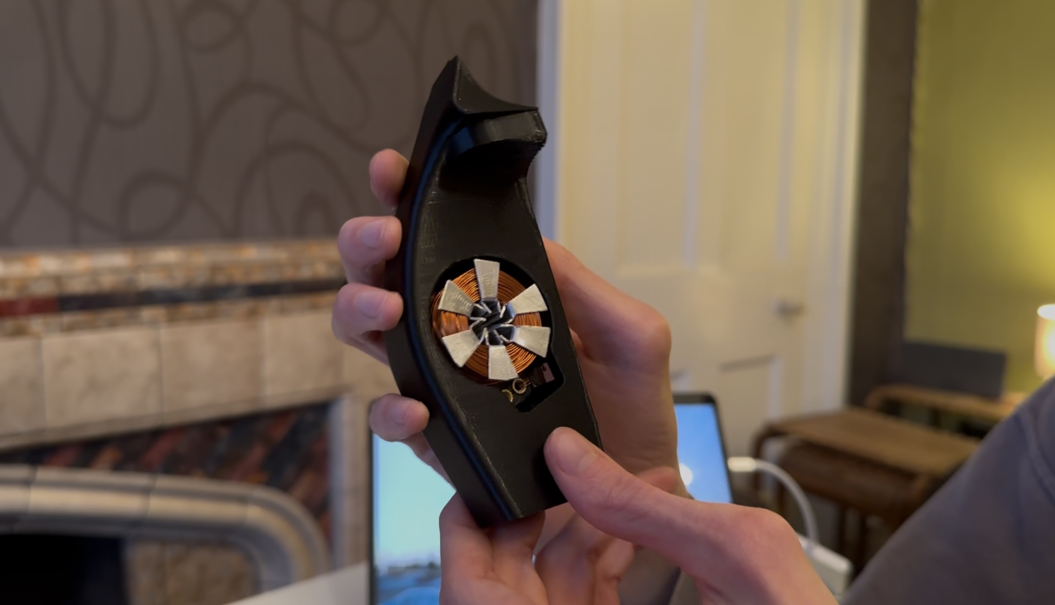 Hand-wound copper coil with laminated iron core segments seated in the 3D-printed shroud